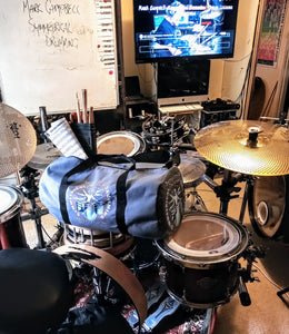 Symmetrical Drumming V3 - Duffel Bag (Grey) - Large kit bag sitting on drums holding drumsticks and sheet music - Keen Eye Design