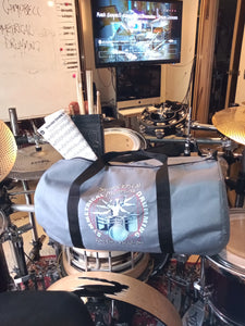 Symmetrical Drumming V3 - Duffel Bag (Grey) - Large kit bag sitting on drums holding drumsticks and sheet music - side view - Keen Eye Design