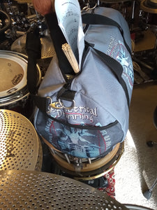 Symmetrical Drumming V3 - Duffel Bag (Grey) - Large kit bag sitting on drums holding drumsticks and sheet music - end view with webbed pouch - Keen Eye Design